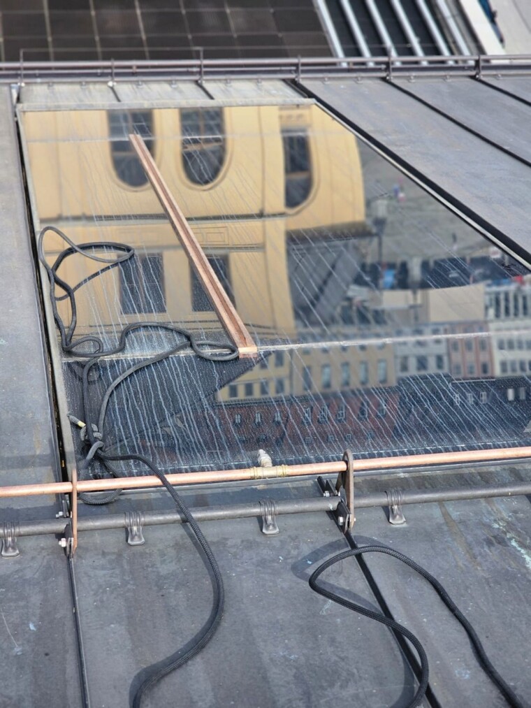 Dachverglasung vor der Reinigung mit sichtbaren Spuren auf den Glasscheiben und Seilen auf dem angrenzenden Metalldach.
